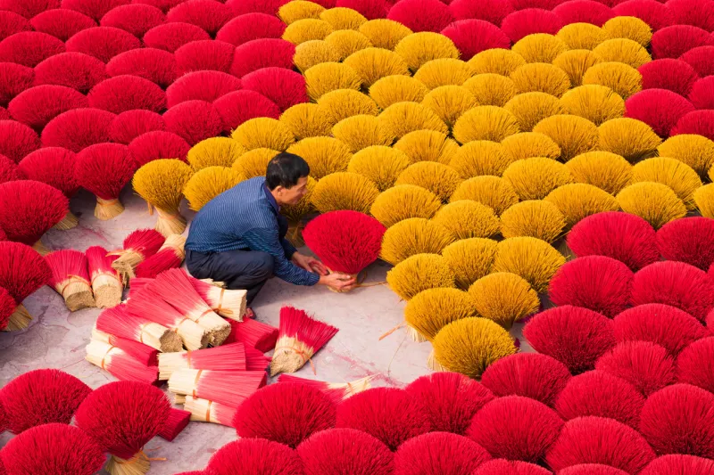 Quang Phu Cau Village has been producing incense for over a century. Generations of villagers have passed down the art of incense-making—rolling bamboo sticks, dyeing them in bright hues, and drying them under the sun. Today, the village is not only a center for incense production but also a popular tourist attraction, especially during the weeks leading up to Lunar New Year when demand for incense peaks.